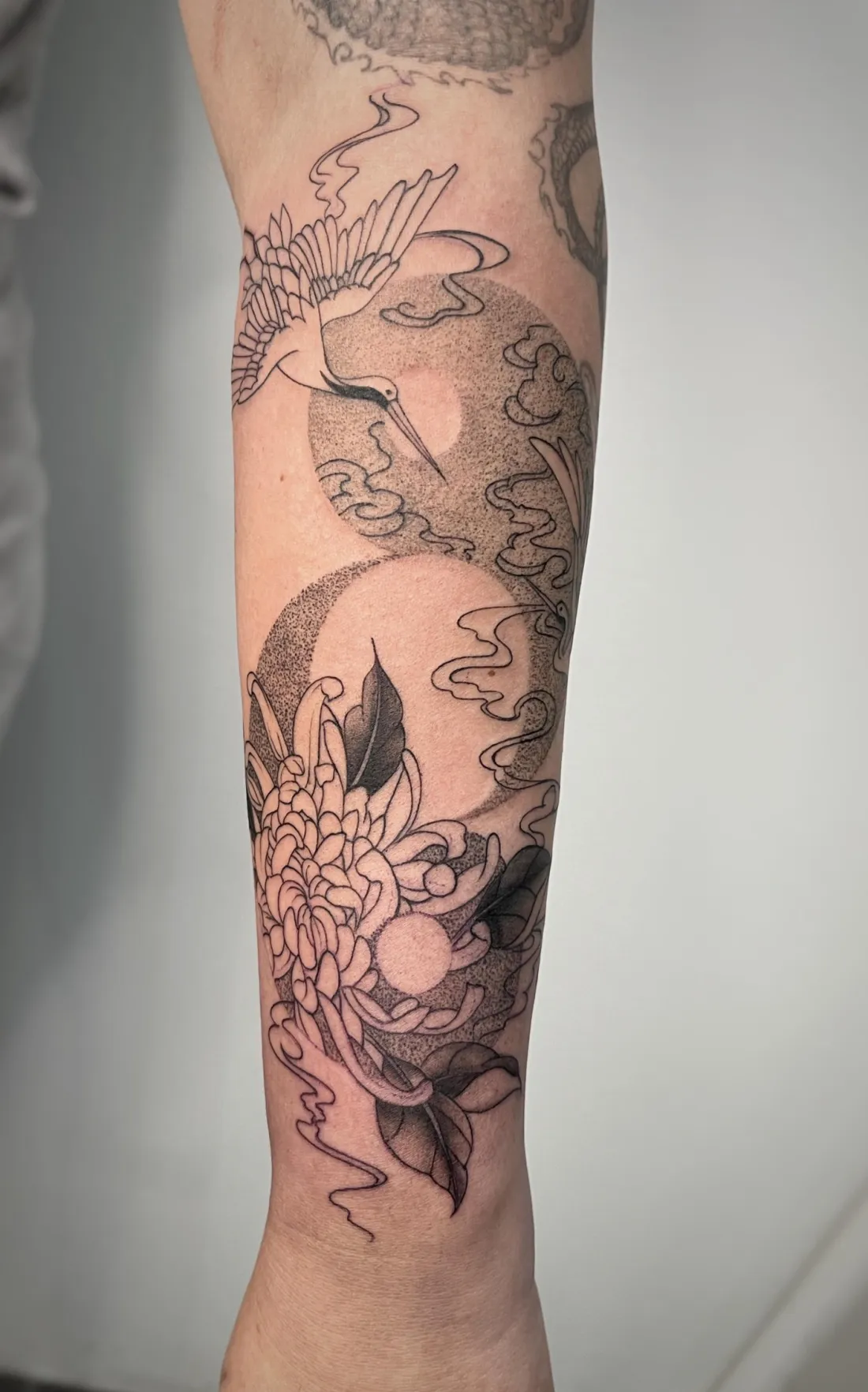 Kranich mit Chrysantheme am Unterarm — Fine Line Tattoo von Alexander